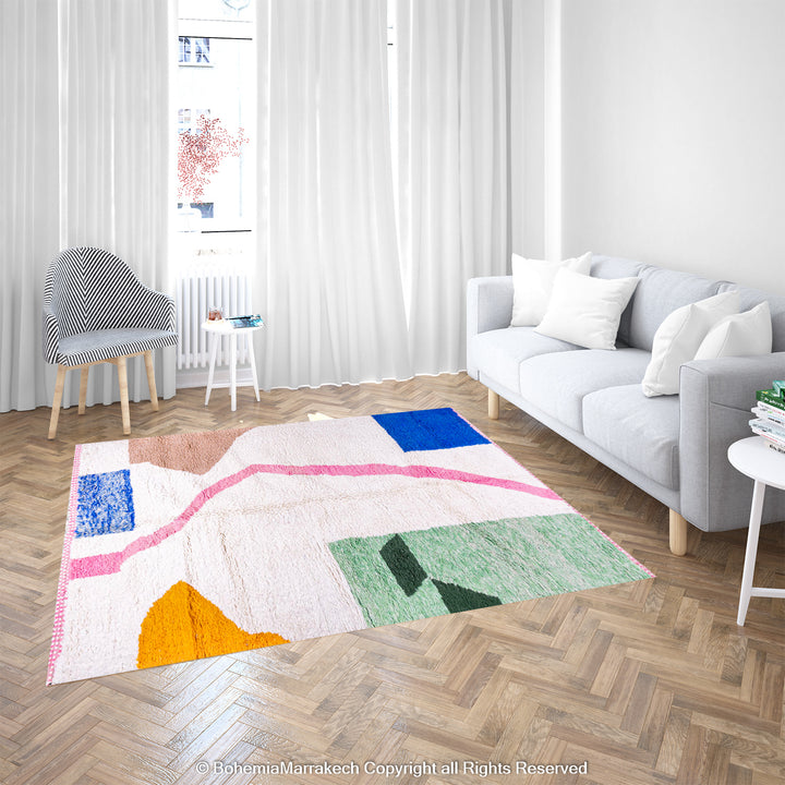 Handmade Moroccan wool rug with colorful abstract design in blue, green, yellow, and pink on ivory base in modern living room.