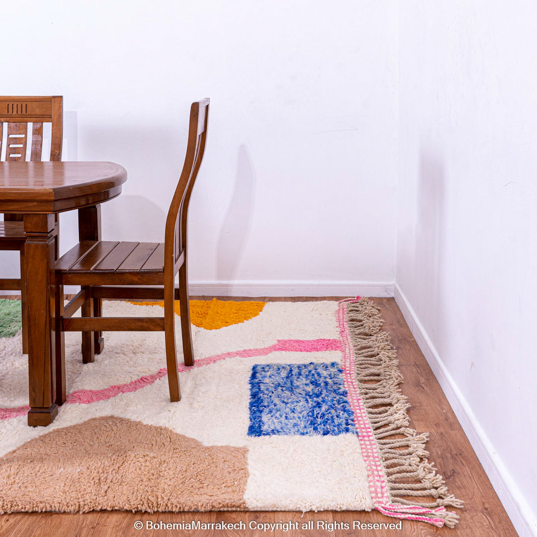 Colorful handmade Moroccan wool shag rug with abstract design, featuring blue, green, yellow, and pink blocks of color on ivory base.