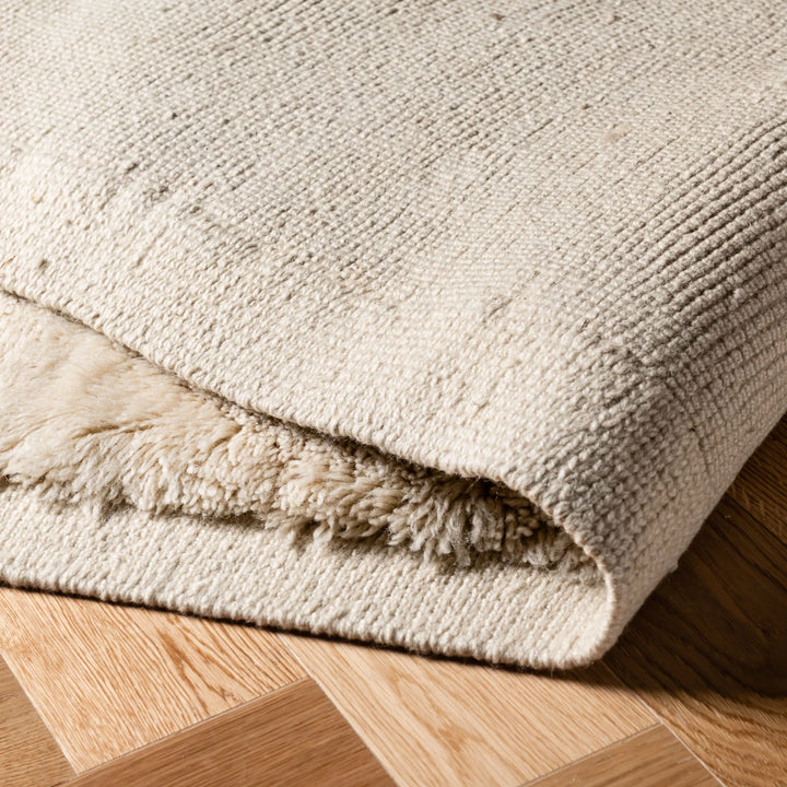 Close-up of beige Moroccan wool rug with minimalist design, showcasing plush texture and craftsmanship. Perfect for modern interiors.