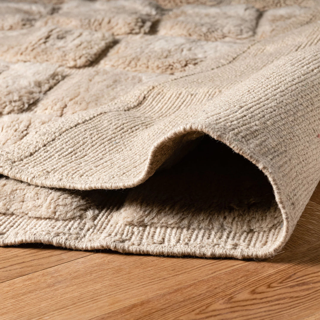 Handcrafted beige Moroccan wool rug with textured grid pattern, perfect for modern interiors. Authentic, luxurious, and artisanal.