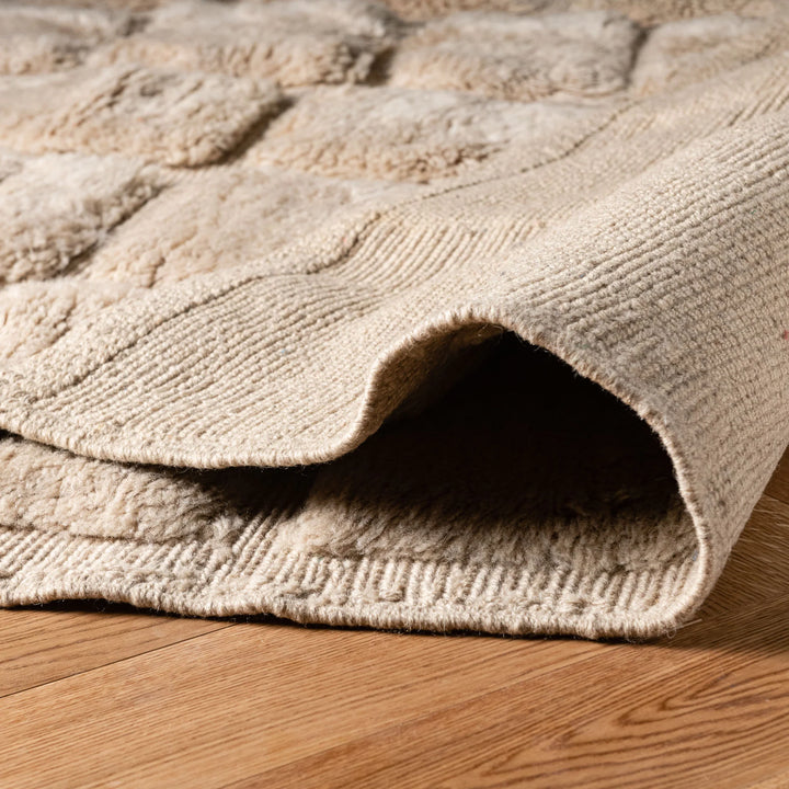 Handcrafted beige Moroccan wool rug with textured grid pattern, perfect for modern interiors. Authentic, luxurious, and artisanal.
