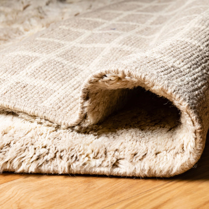 Beige Moroccan wool rug with subtle grid pattern, handwoven for softness and warmth; ideal for minimalist or Scandinavian decors.