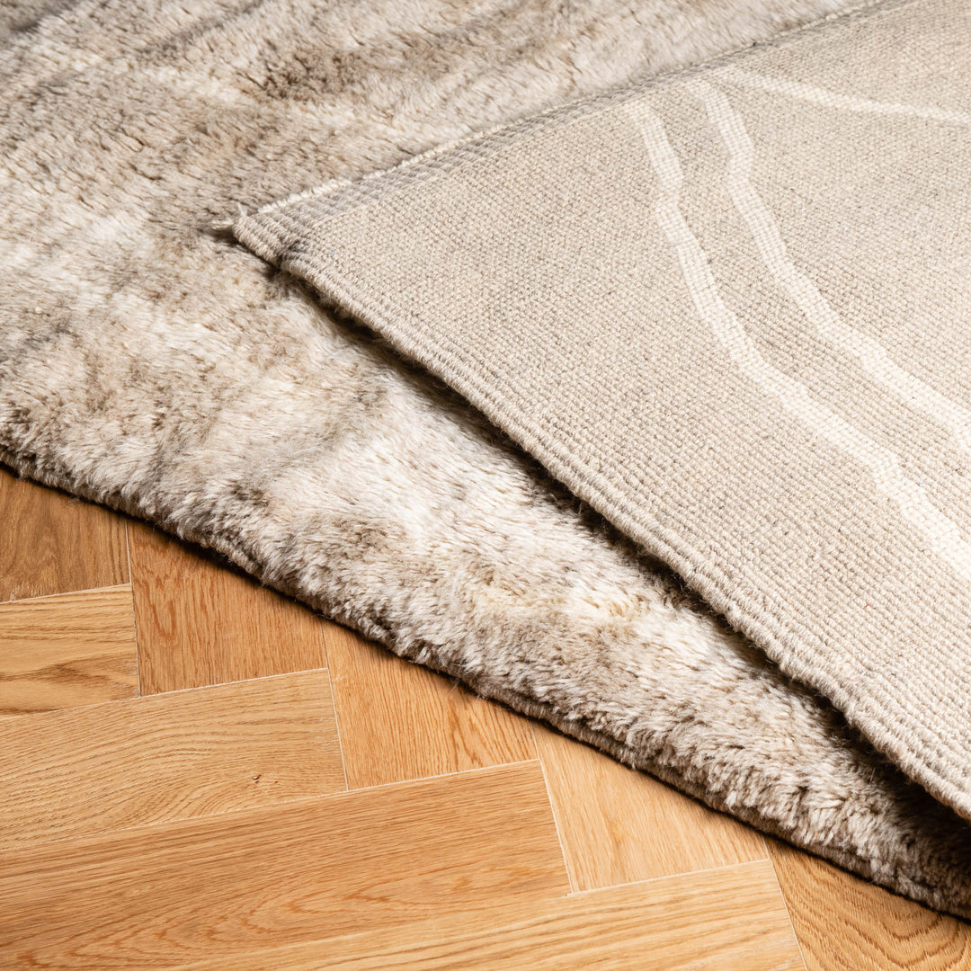 Beige Wool Beni Ourain Rug with Berber diamond patterns on hardwood floor, showcasing Moroccan craftsmanship and elegance.