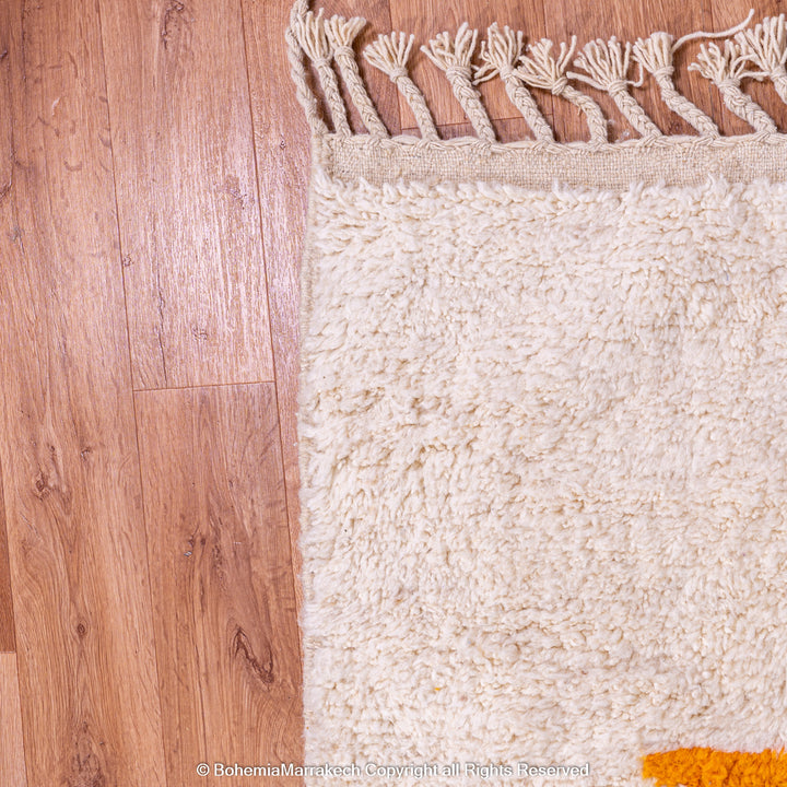 Handmade Moroccan wool rug with abstract orange and beige block design on cream background