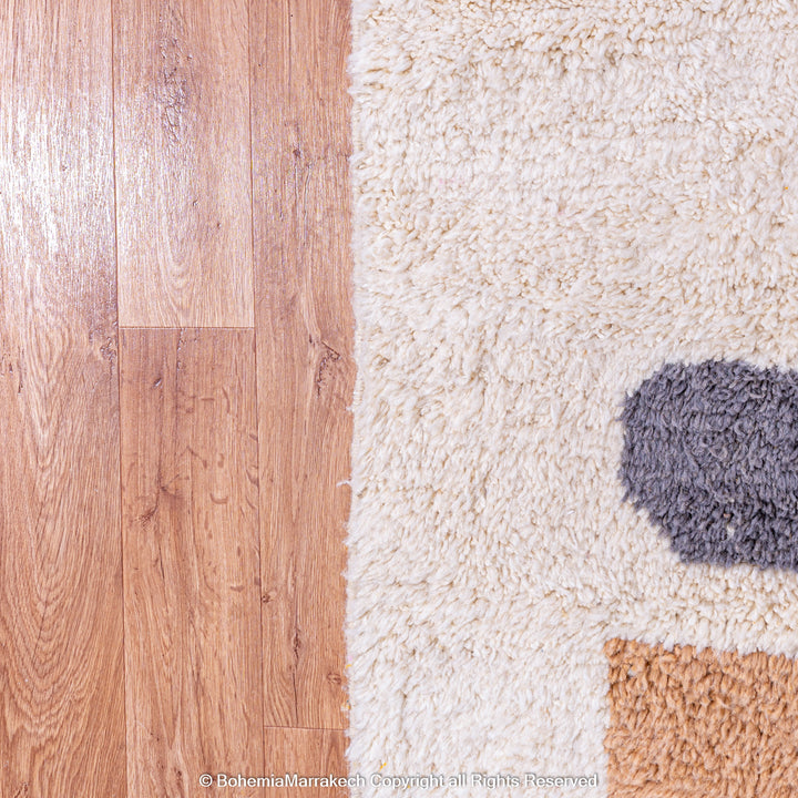 Handmade Moroccan wool rug with abstract orange and beige block design on cream background