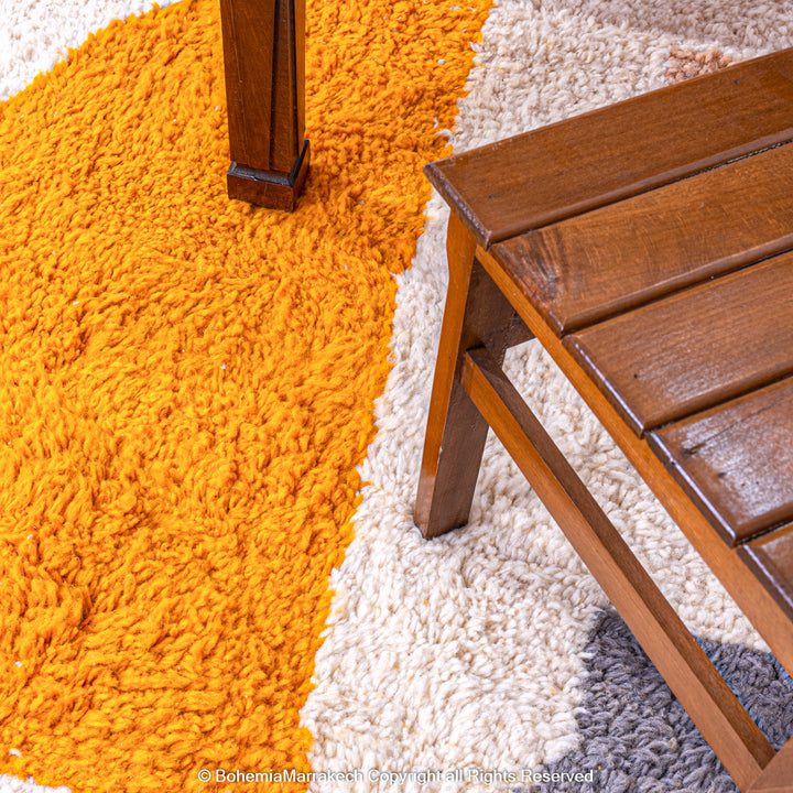Handmade Moroccan wool rug with abstract orange and beige block design on cream background