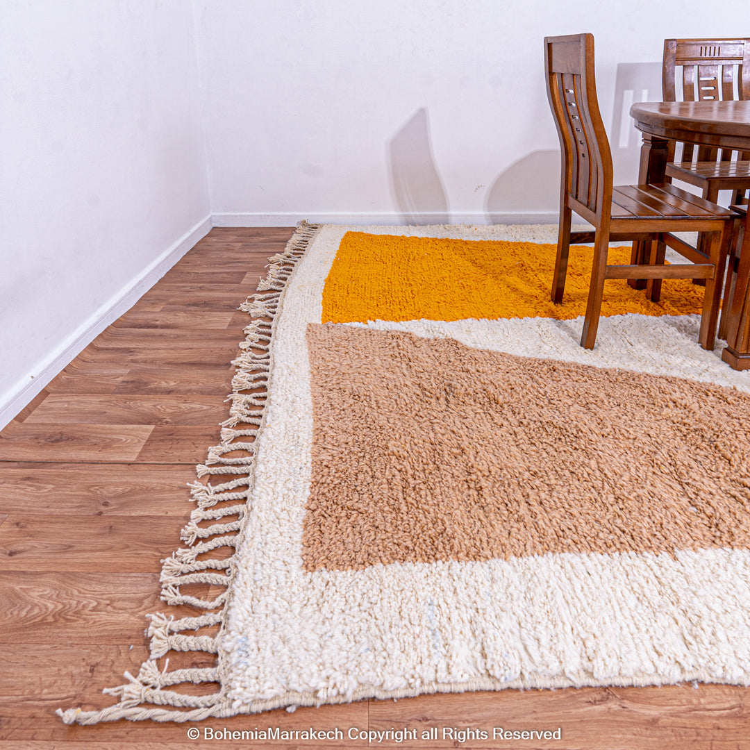 Handmade Moroccan wool rug with abstract orange and beige block design on cream background