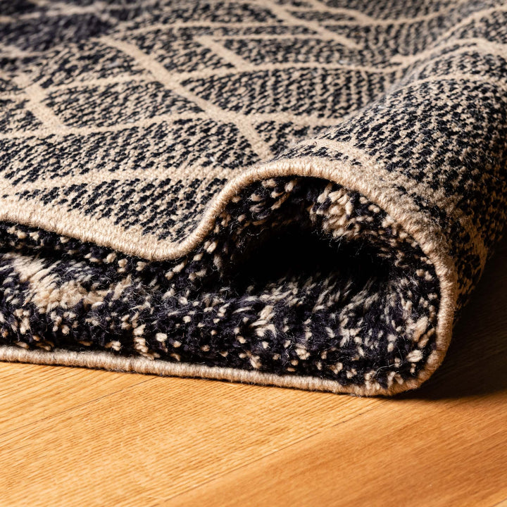 Close-up of Black Diamond Pattern Beni Mrirt Moroccan Rug on wooden floor, showcasing handmade wool texture and geometric design.