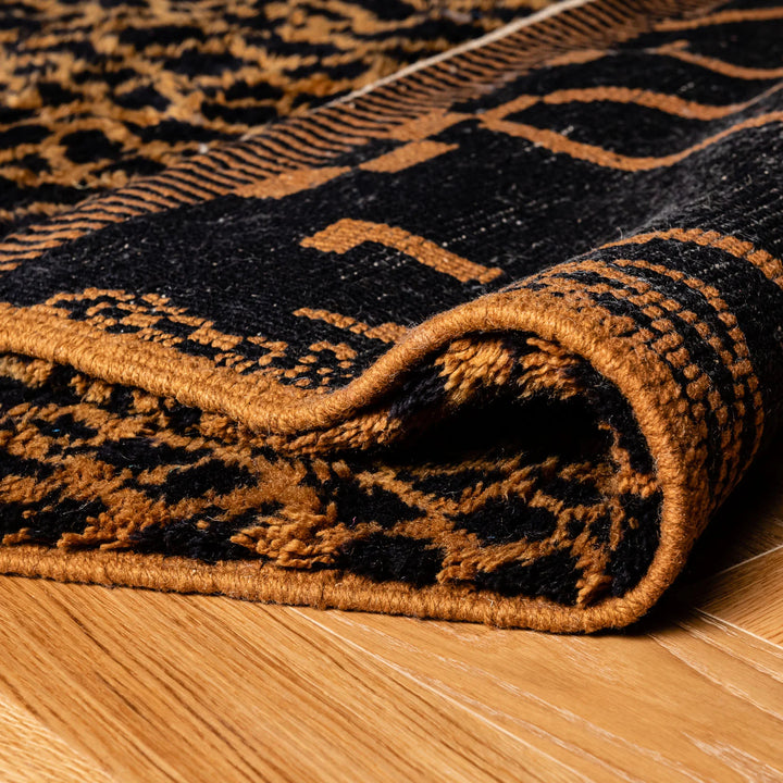 Black & Amber Moroccan Wool Rug with Geometric Tribal Design on Hardwood Floor