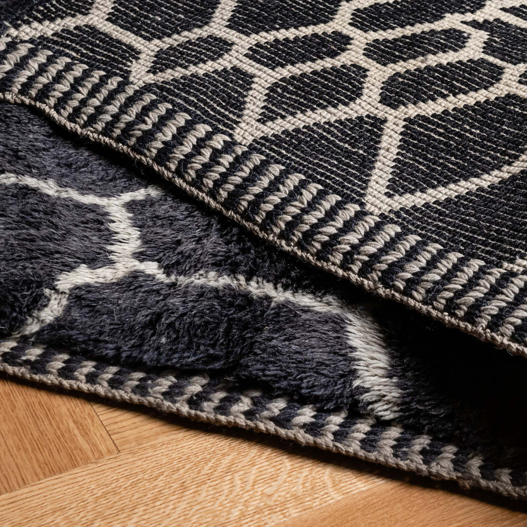 Handmade black and white Moroccan wool rug with abstract geometric design, showcasing rich texture and elegance.