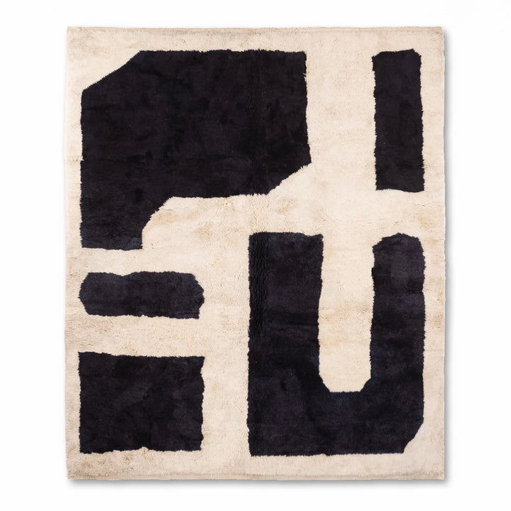 Black and white abstract Moroccan rug with bold geometric shapes, hand-knotted wool, perfect for modern interiors.