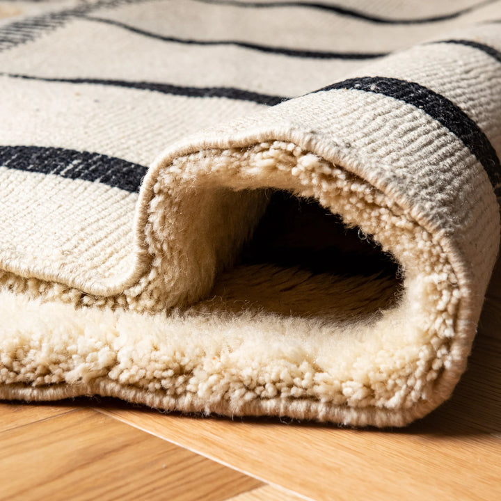 Close-up of handcrafted Black and White Moroccan wool rug with vertical stripes, showcasing soft high-pile texture.