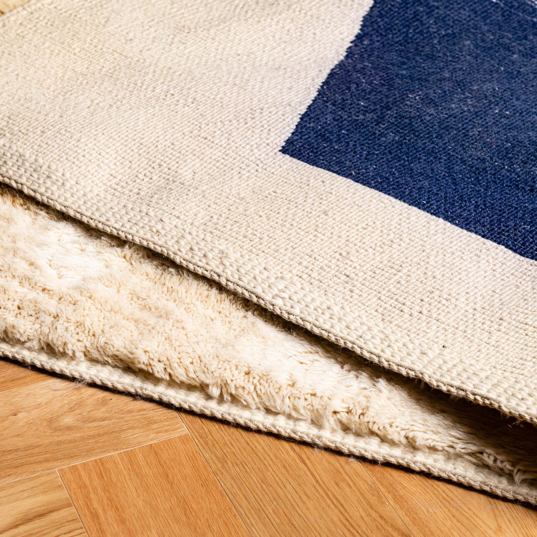 Close-up of a Moroccan Beni Mrirt rug, featuring blue and mustard geometric designs on a soft wool base. Perfect as a Moroccan area rug.