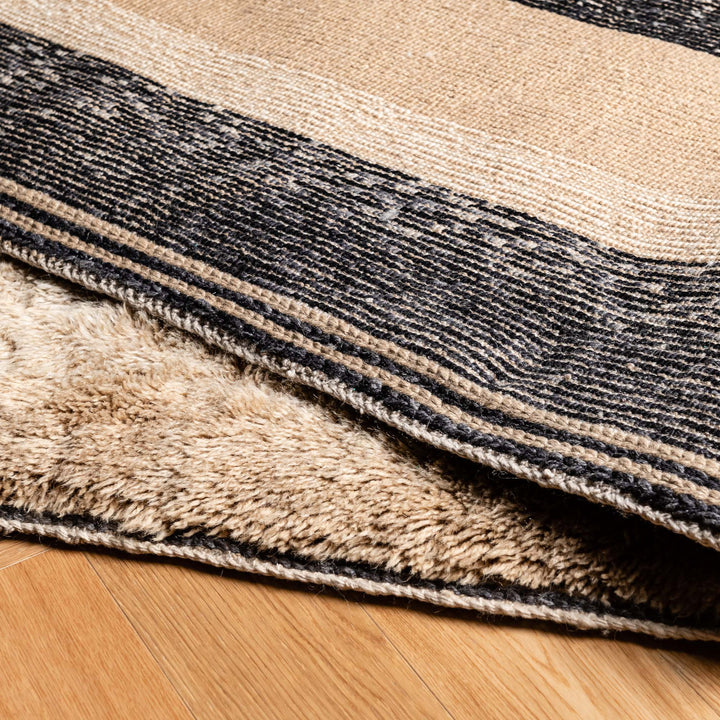 Close-up of a black and beige geometric Moroccan wool rug with a plush texture, showcasing traditional craftsmanship.