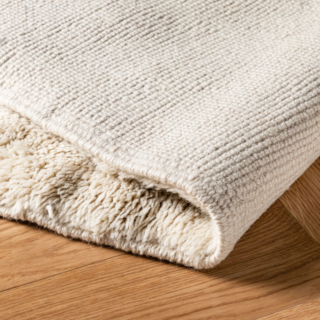 Close-up of handmade Moroccan wool rug showcasing plush texture and ivory finish, perfect for traditional decor and warmth.