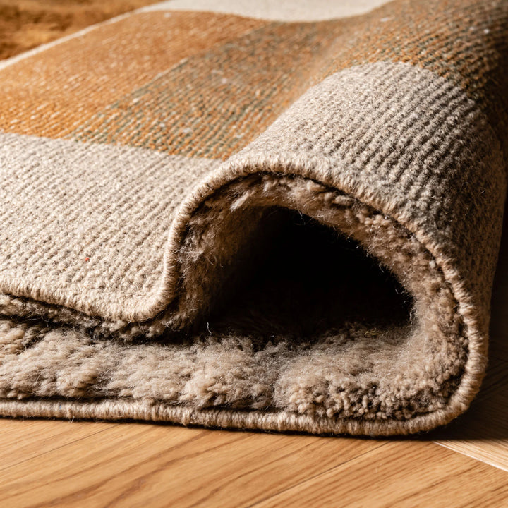 Close-up of rolled Color Block Beni Mrirt Moroccan wool rug, showcasing plush texture and earthy tones.