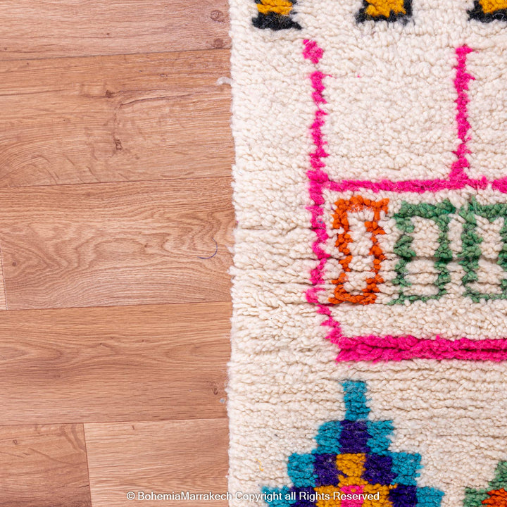 Colorful Azilal Moroccan rug close-up with vivid shapes and symbols on natural wool, handcrafted by Berber women. Bohemian decor.