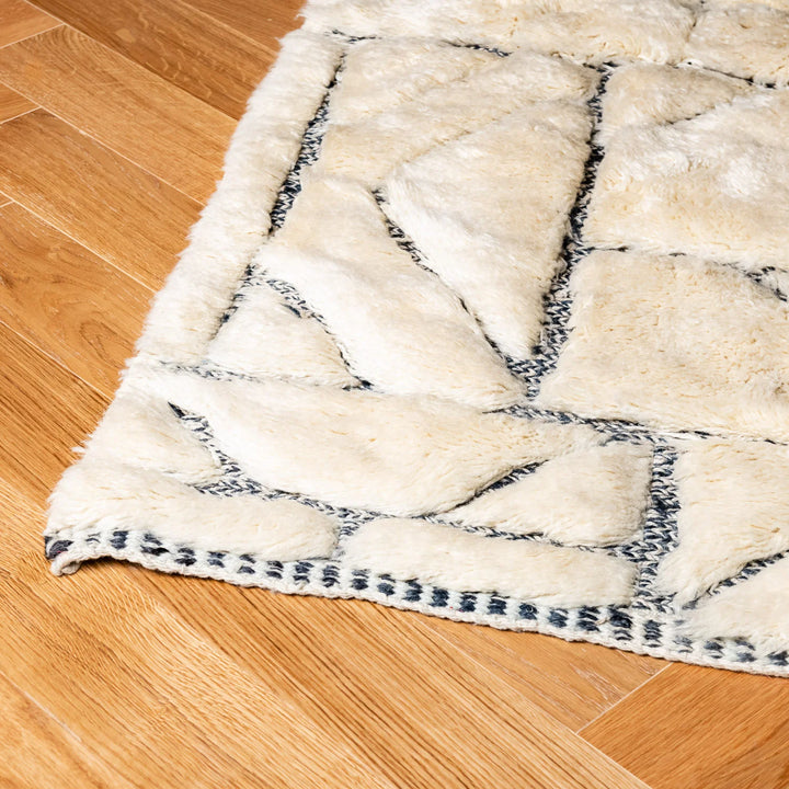 Handmade cream Moroccan wool rug with abstract grid pattern on wooden floor