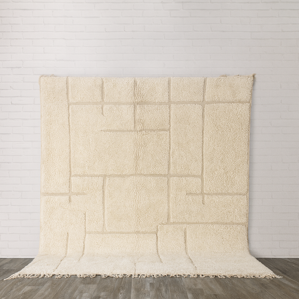 Cream moroccan rug  textured blanket on a wooden floor with a light gray wall background