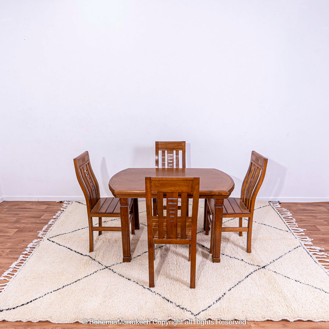 Black and white diamond Moroccan rug under wooden dining set, handmade wool rug adding elegance to room decor.