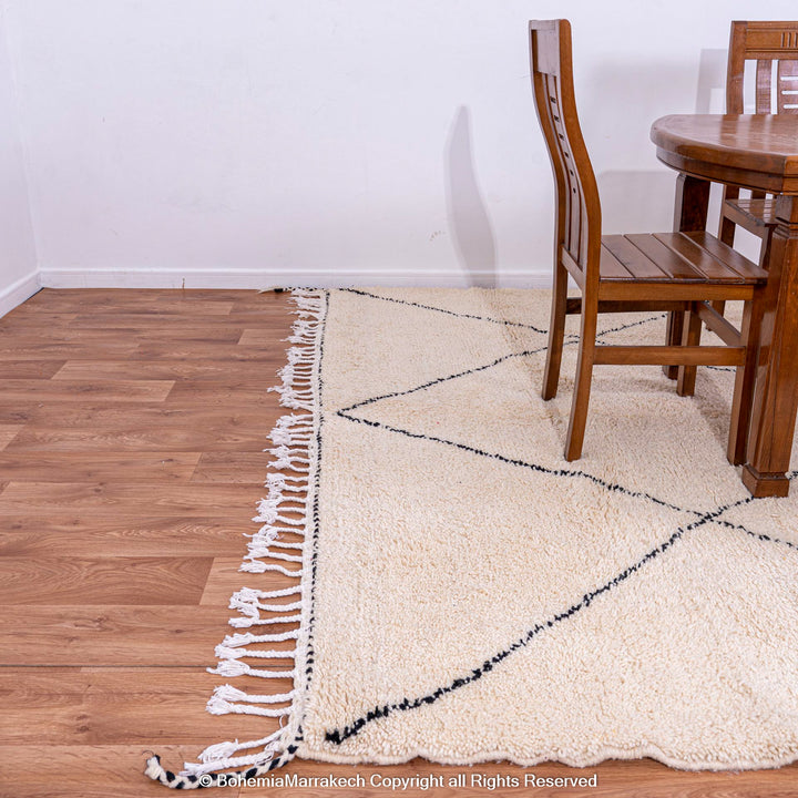 Black and white diamond Moroccan rug on wood floor, handmade wool, minimalist design, traditional decor piece.