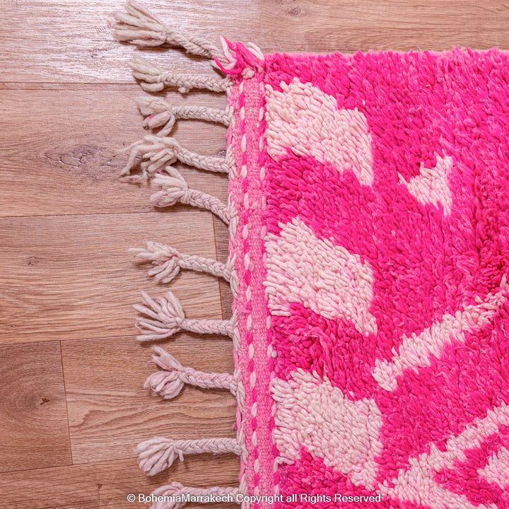 Pink Moroccan Berber rug with white diamond patterns, handmade wool, vibrant and cozy. Moroccan style carpet for modern interiors.