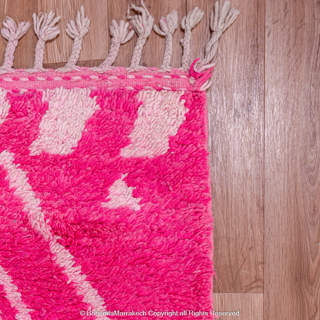 Pink Moroccan Berber rug with white diamond motifs, handmade from natural wool. Vibrant and cozy, perfect for modern interiors.