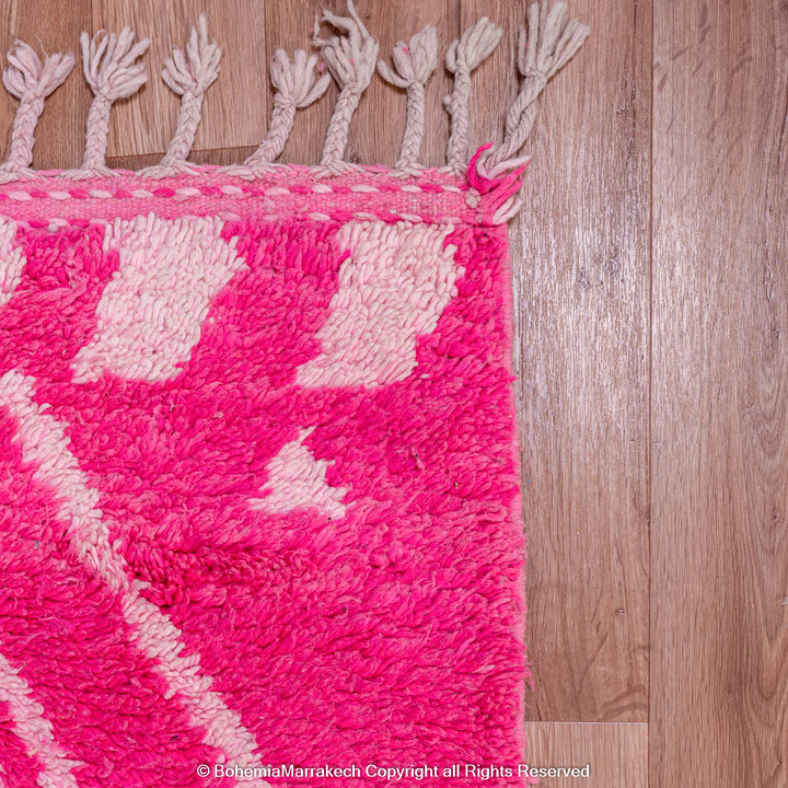 Pink Moroccan Berber rug with white diamond motifs, handmade from natural wool. Vibrant and cozy, perfect for modern interiors.