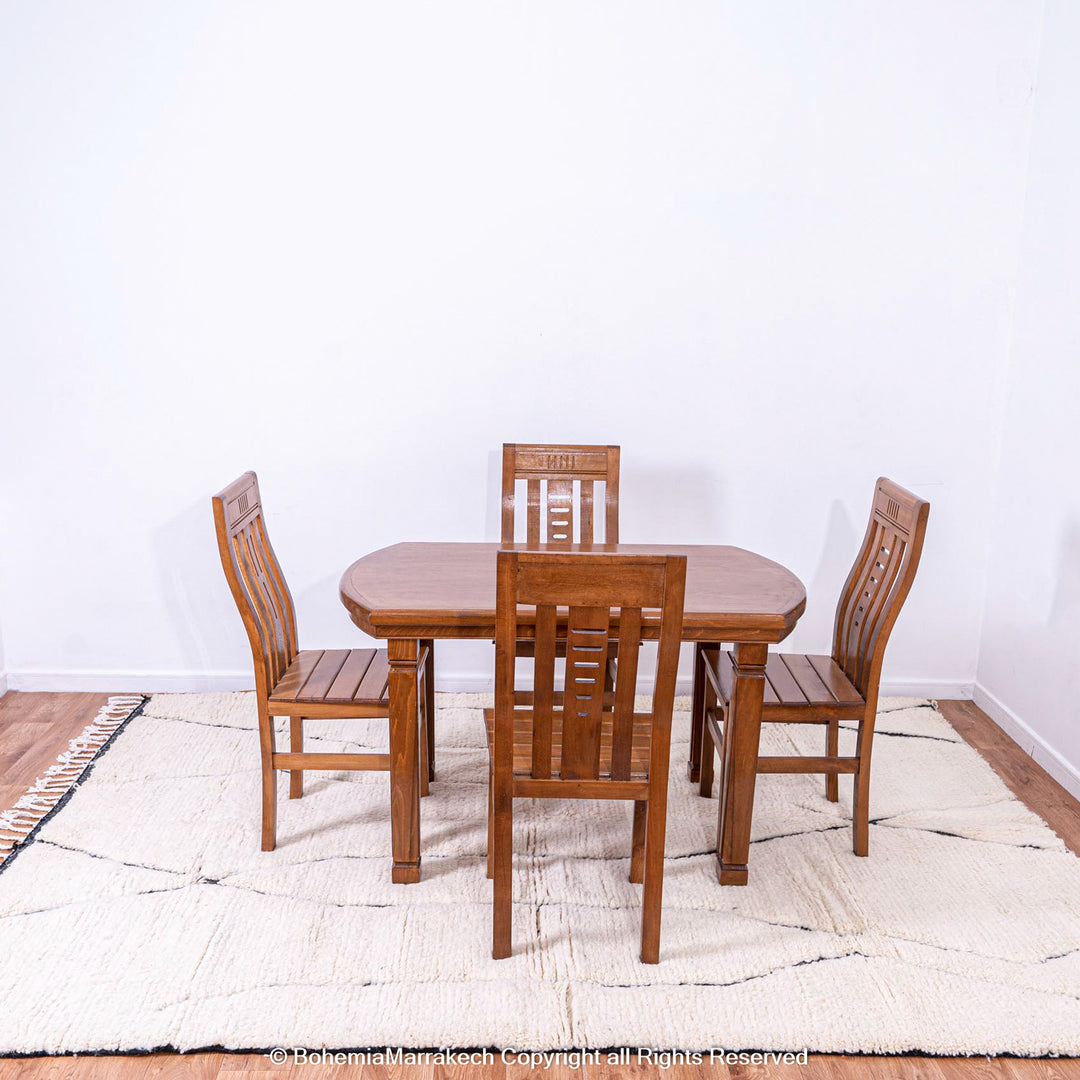 Wooden dining set on a white Moroccan rug with black lines, showcasing a Beni Ourain style made from natural wool.