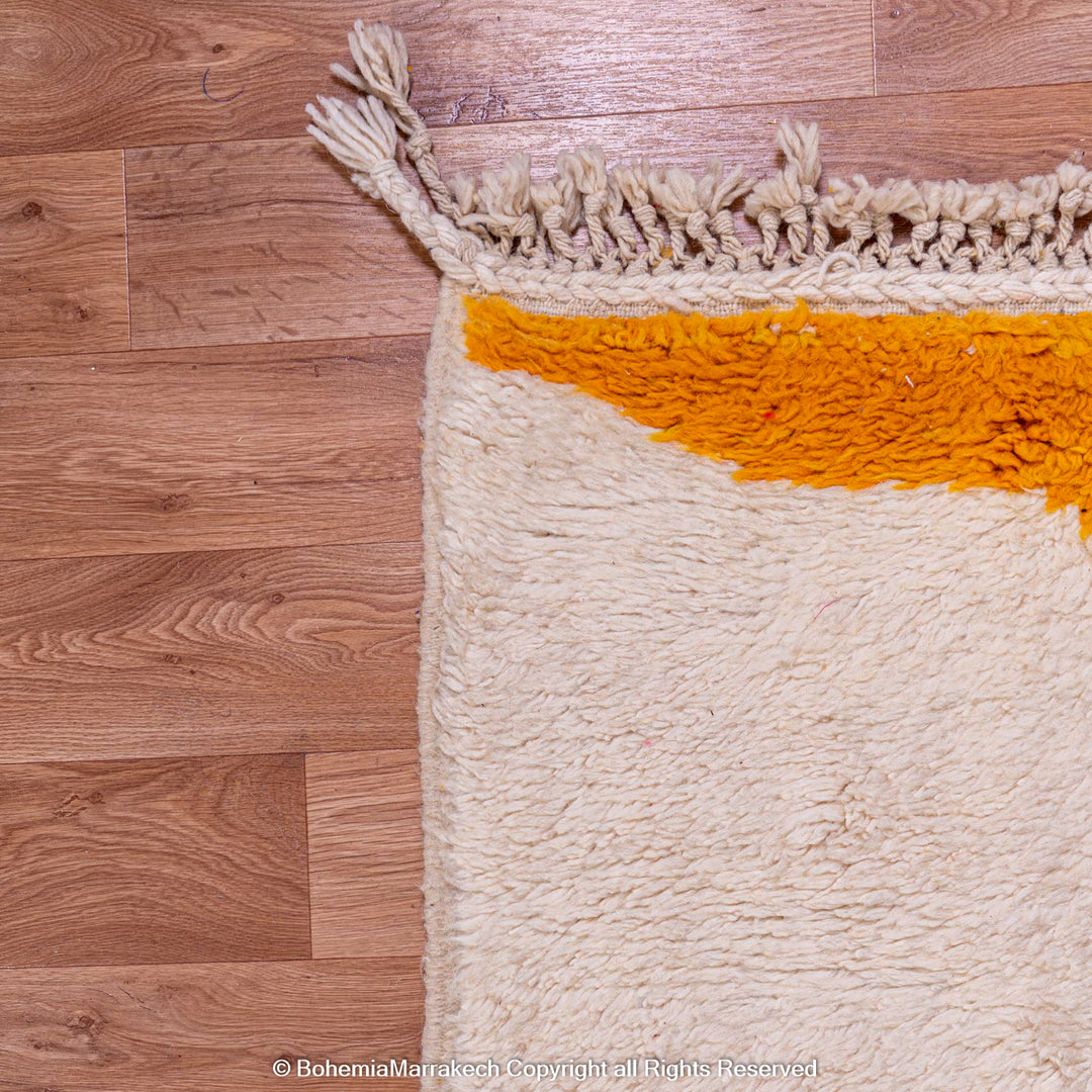 Yellow Moroccan wool rug with abstract design on hardwood floor