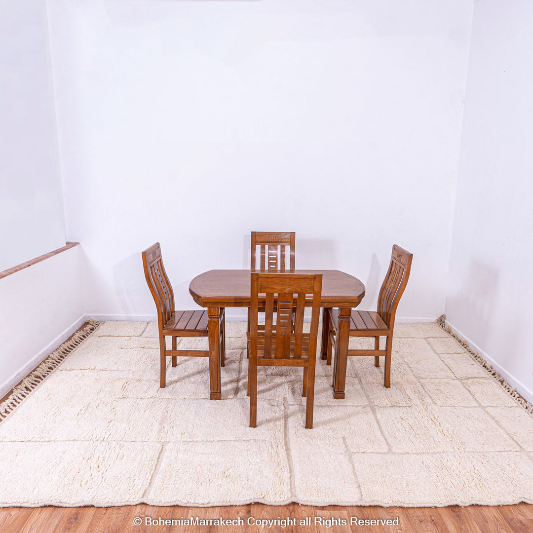 White Grid Moroccan rug under wooden dining table in minimalist room.