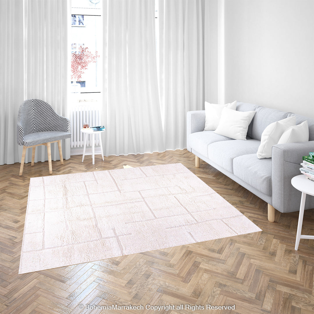 White Moroccan wool rug with geometric grid pattern in a modern living room.
