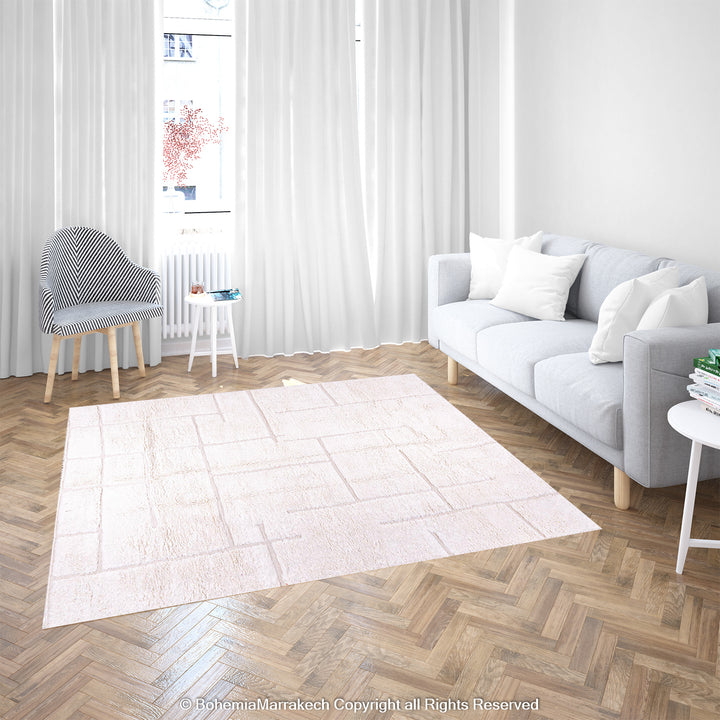 White Moroccan wool rug with geometric grid pattern in a modern living room.
