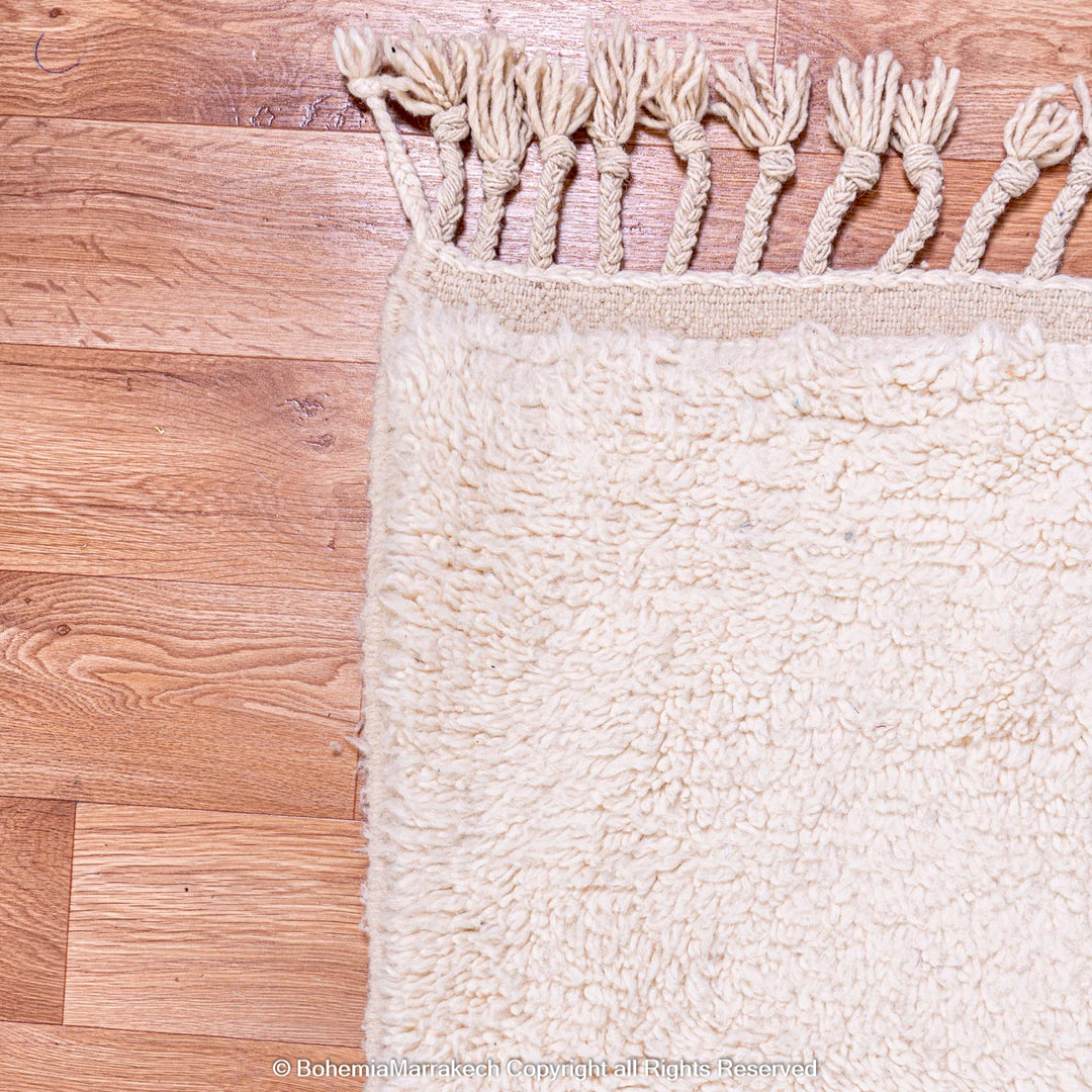 White Moroccan wool rug with fringe, showcasing traditional Beni Ourain style and minimalist grid pattern. Ideal for modern decor.