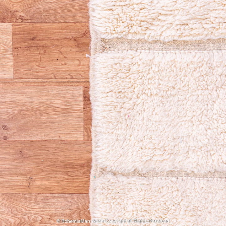 White grid Moroccan wool rug with subtle lines on wooden floor, perfect for modern or Scandinavian decor.