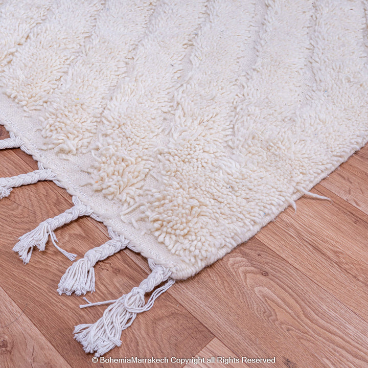 Handmade white Moroccan rug with subtle V texture, ideal for minimalist and modern interiors. Features fringes, 100% natural wool.