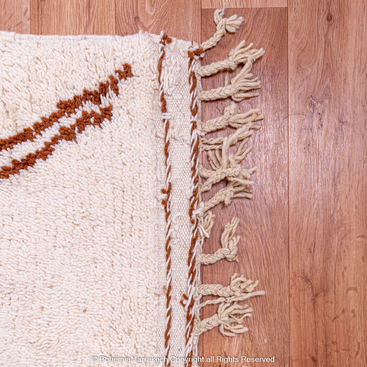 Handwoven Modern Moroccan Rug with brown and beige abstract design on wooden floor, showcasing intricate Berber craftsmanship.