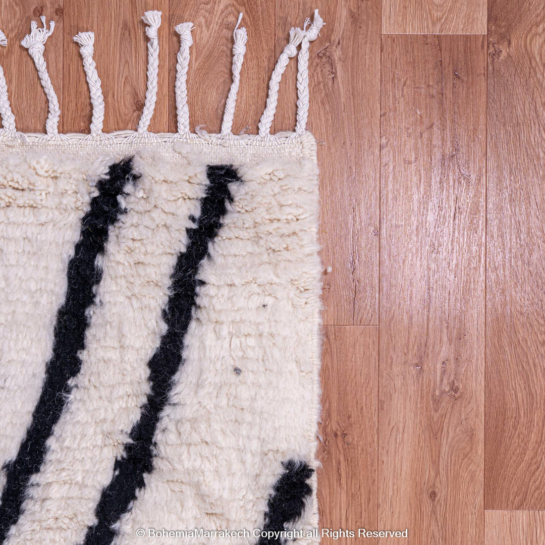 Black and White Beni Ourain Moroccan Wool Rug with Abstract Criss-Cross Patterns on a Wooden Floor