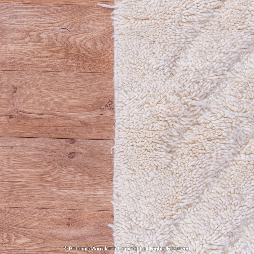 White Moroccan rug with subtle V-line texture on wooden floor. Perfect for minimalist and Scandinavian interiors.
