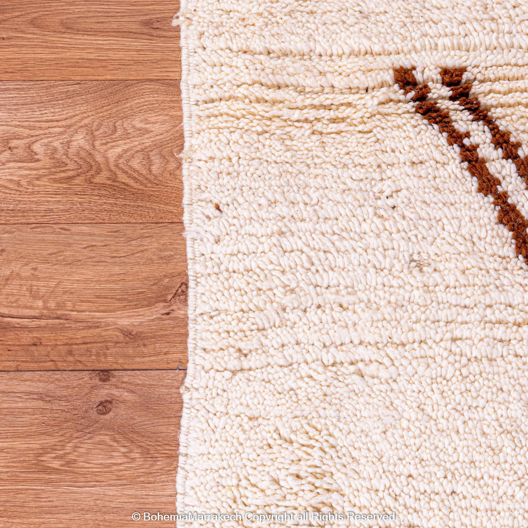 Abstract brown and beige Moroccan Berber rug detail, showcasing handwoven wool textures on wooden floor.