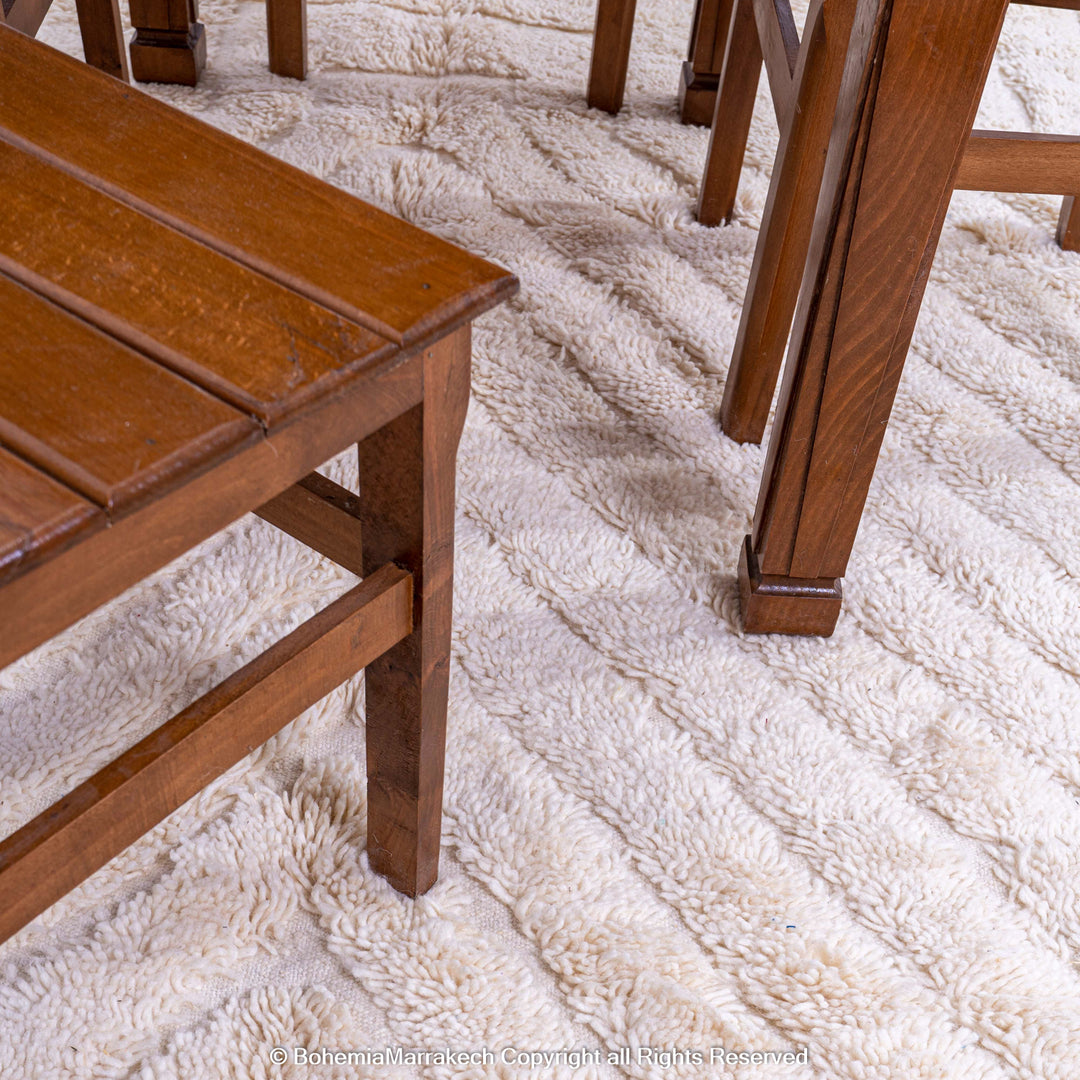White Moroccan rug with subtle V-line texture under a wooden dining table, ideal for modern interiors.