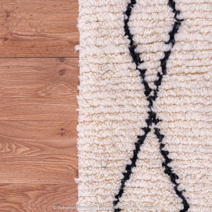 White Moroccan Rug with Abstract Black Diamonds, Handmade Woolen Texture on Wooden Floor