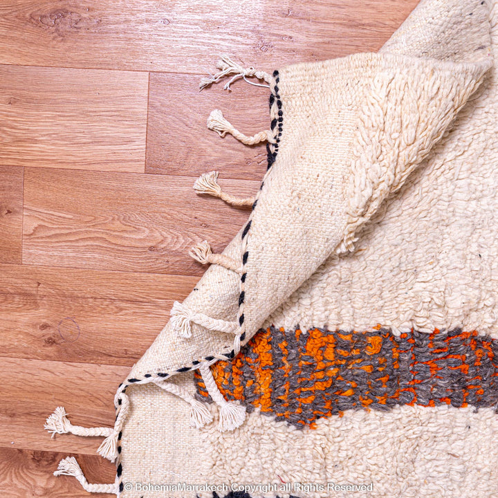 Detailed view of Striped Abstract Moroccan Rug with orange and grey pattern on creamy background, handmade wool carpet.