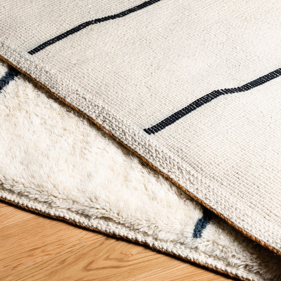 Close-up of a handmade Moroccan Beni Mrirt wool rug with abstract linear patterns, featuring plush texture for luxurious interiors.