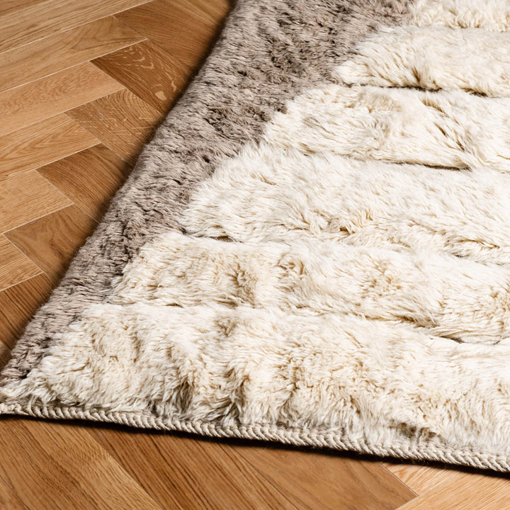 Close-up of a custom Beni Mrirt rug with hourglass shaved wool design on wooden floor, showcasing cream and gray Moroccan wool textures.