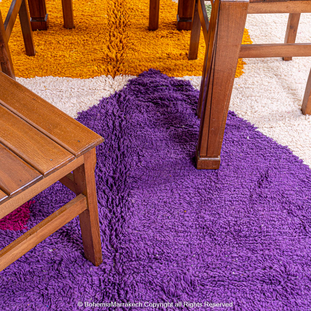 Abstract Moroccan wool rug with orange and purple geometric shapes on cream background