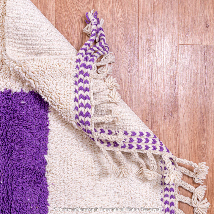 Abstract Moroccan wool rug with orange and purple geometric shapes on cream background
