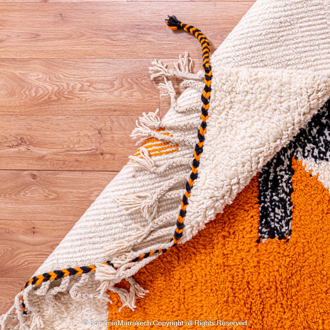 Abstract Beni Ourain Moroccan rug with colorful geometric shapes in orange, pink, black, and teal on a white wool background