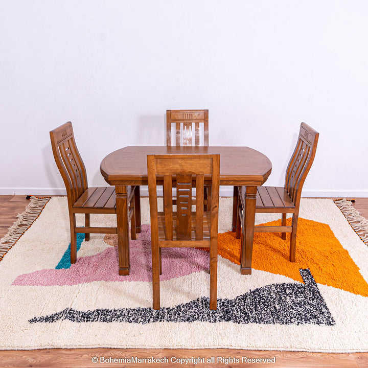 Abstract Beni Ourain Moroccan rug with colorful geometric shapes in orange, pink, black, and teal on a white wool background