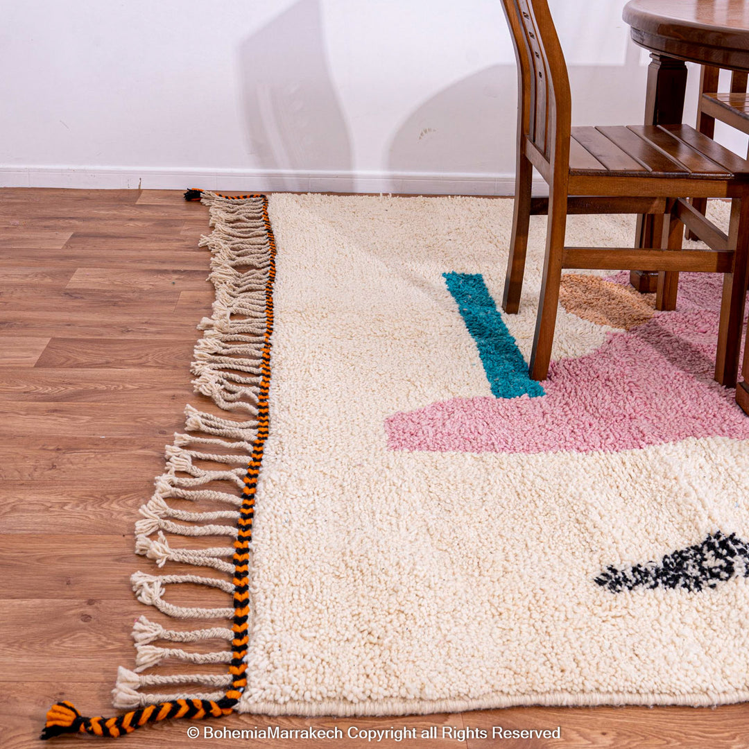 Abstract Beni Ourain Moroccan rug with colorful geometric shapes in orange, pink, black, and teal on a white wool background